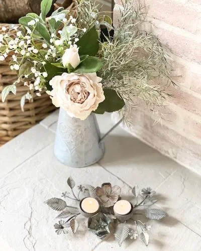 Antique zinc tealight holder with ornate leaves.